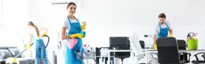 Commercial cleaning company team with spray bottle, cleaning cart, and vacuum machine providing janitorial services in a modern office.